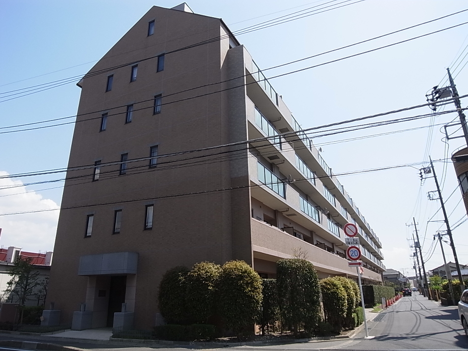 緑の植栽が映えるブラウンカラーの外観です